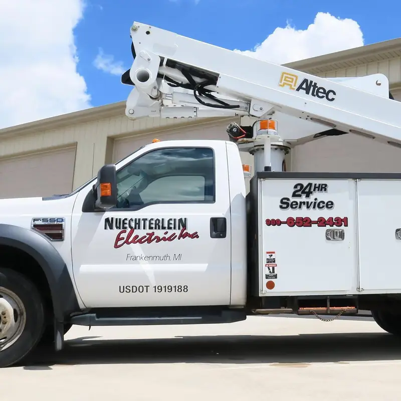 The Nuechterlein Electric aerial boom truck, lettered Frankenmuth, MI and 24HR Service.